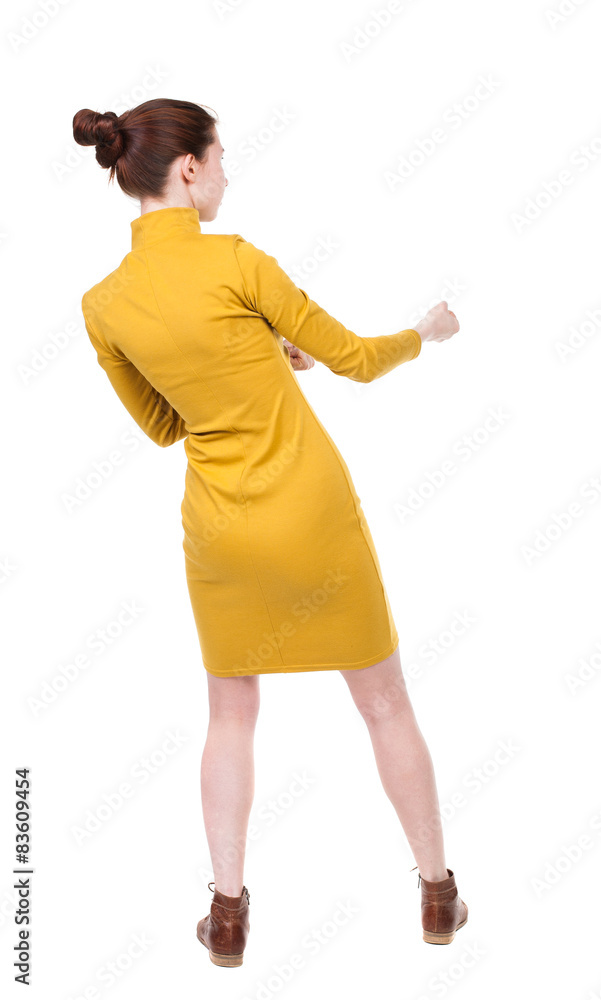 Fototapeta premium back view of standing woman pulling a rope from the top or cling