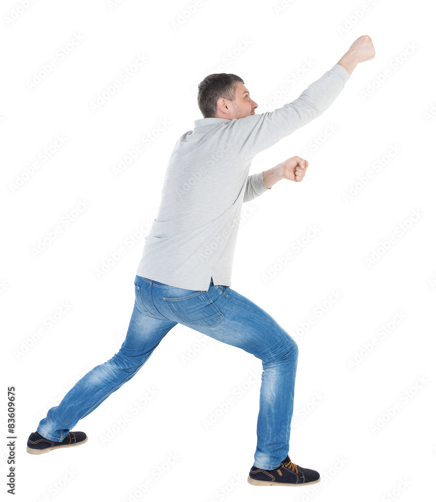 back view of standing man pulling a rope from the top or cling t