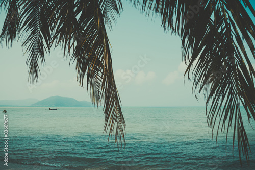 Retro stylized palm leaf and tropical beach