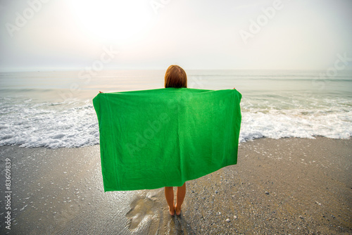 Tableau sur toile Woman in green towel on the beach