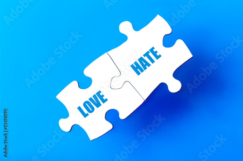 Connected puzzle pieces with words LOVE and HATE