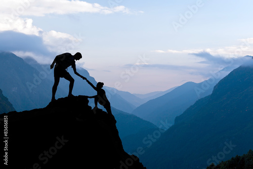Teamwork couple climbing helping hand
