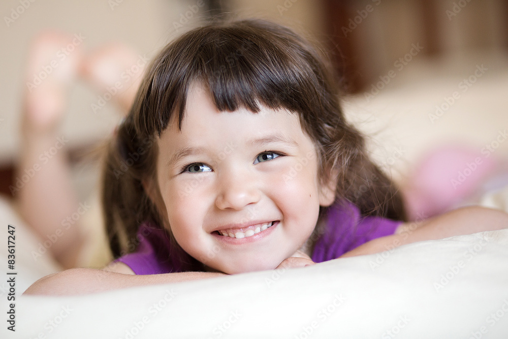 Adorable little girl smiling lying on the bed Adorable little girl smiling lying on the bed
