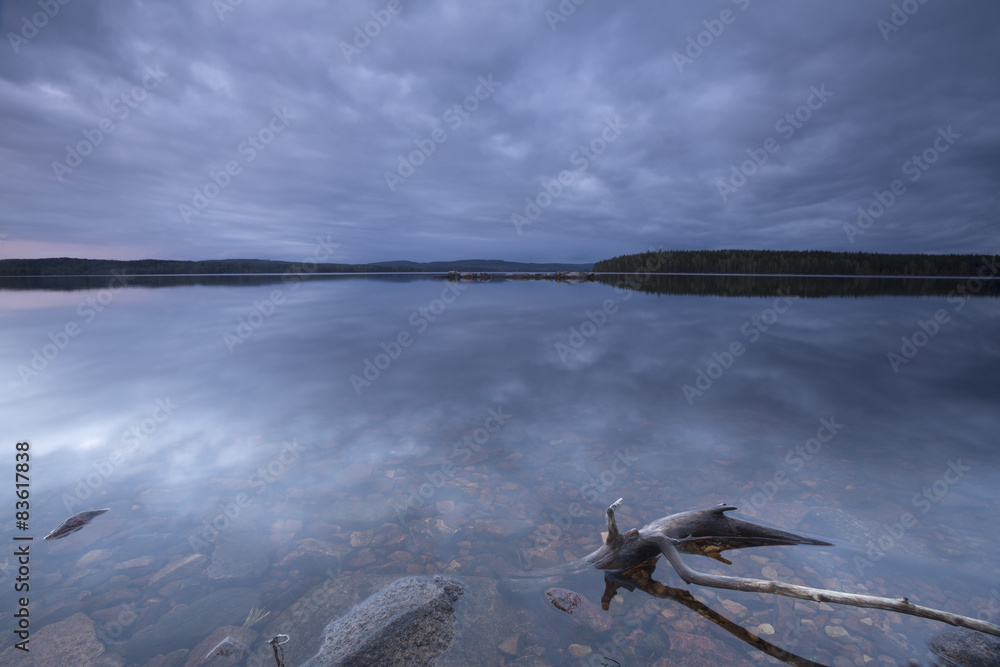 Fototapeta premium Calm lake at twilight, wood in the foreground, dalarna, sweden