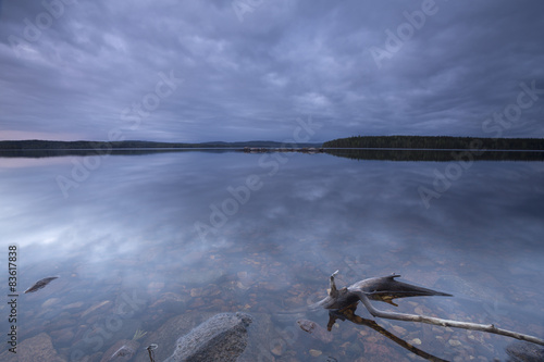 Calm lake at twilight, wood in the foreground, dalarna, sweden