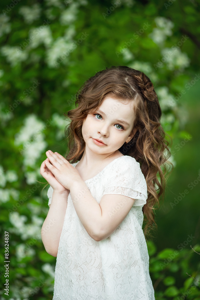 Portrait beautiful little girl near blossoming apple-tree Portrait beautiful little girl near blossoming apple-tree