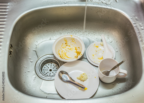 Kitchen conceptual image. Dirty sink with many dirty dishes.