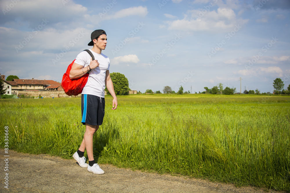 Handsome young man outdoor hiking on rural road Handsome young man outdoor hiking on rural road