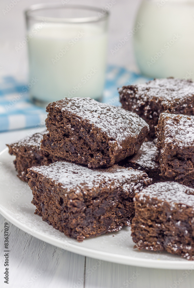 Sugar powdered homemade brownies with glass of milk Sugar powdered homemade brownies with glass of milk