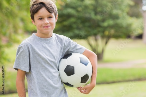 Smiling boy holding a soccer ball in the park © WavebreakMediaMicro