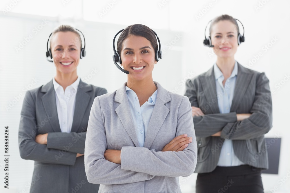 Business team wearing headsets and standing arms crossed Business team wearing headsets and standing arms crossed