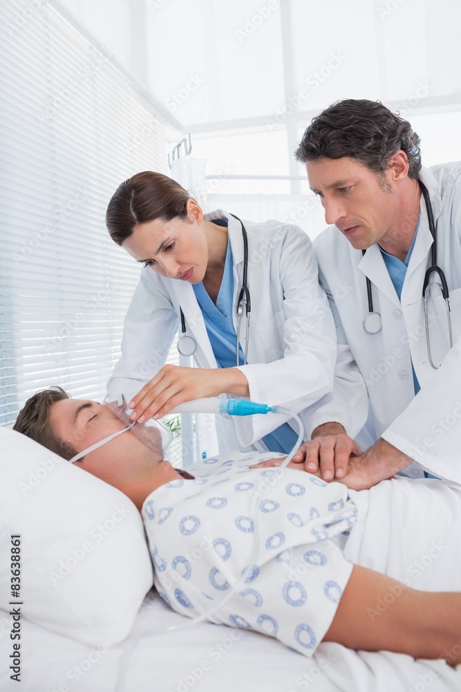 Obraz premium Worried doctors doing heart massage and holding oxygen mask