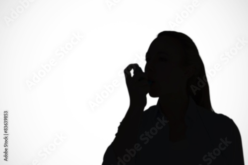Composite image of pretty blonde using an asthma inhaler