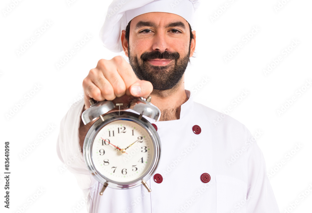 Chef holding a clock over white background Chef holding a clock over white background