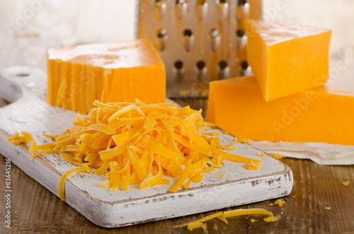 Grated Cheddar Cheese on a Cutting Board.