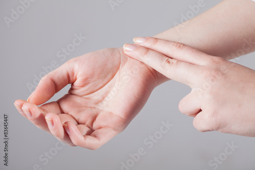 Women listen to the pulse of the hands on a white background photo