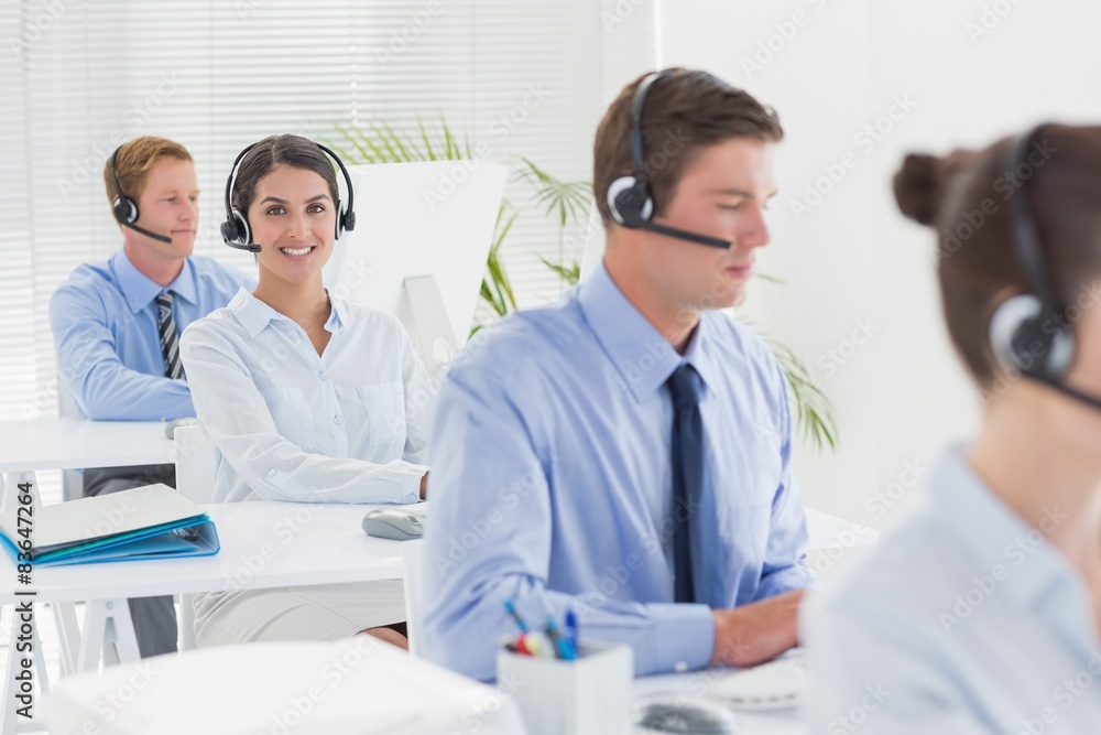 Business team working on computers and wearing headsets Business team working on computers and wearing headsets