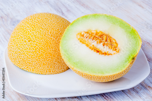 Ripe Galia melon and its slice on plate