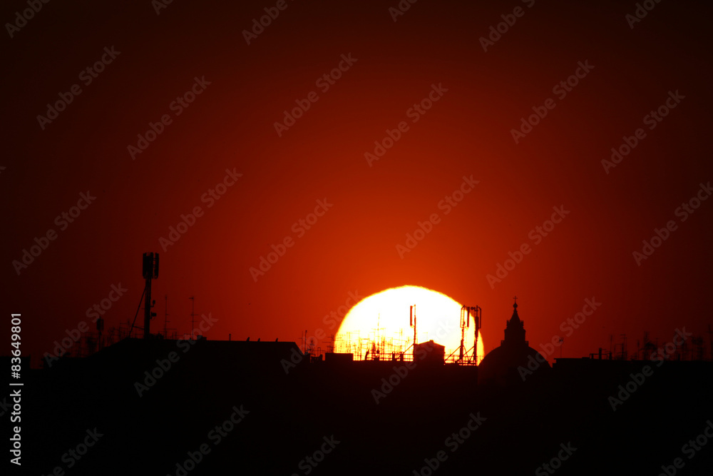 sole al tramonto a roma con antenne
