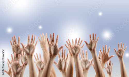 Many people's hands up isolated on blue background. 