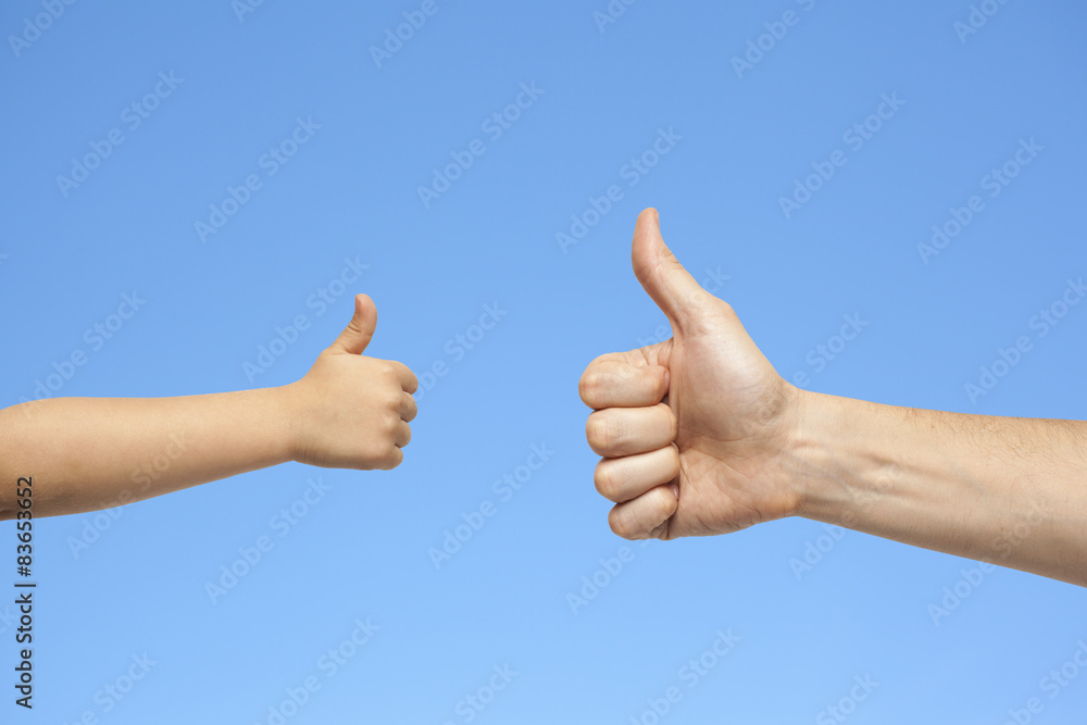 father and son hands giving like on sky background father and son hands giving like on sky background