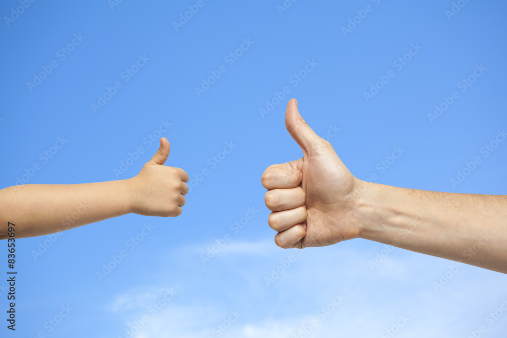 father and son hands giving like on sky background father and son hands giving like on sky background