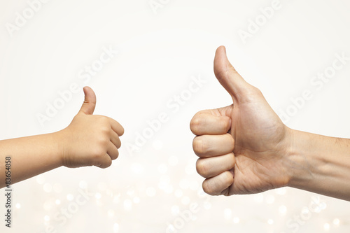 father and son hands giving like on christmas lights background