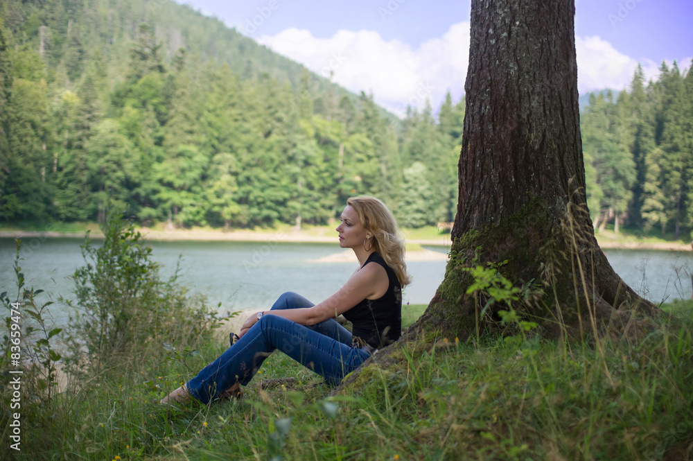Woman sitting near the lake Woman sitting near the lake
