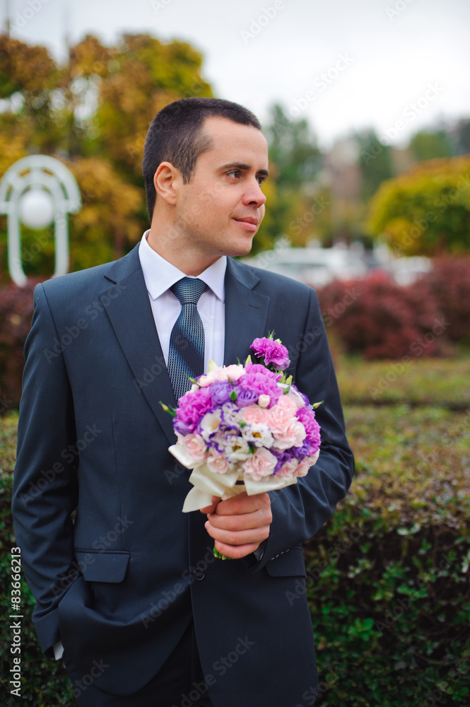 Groom with wedding bouquet in his hands Groom with wedding bouquet in his hands