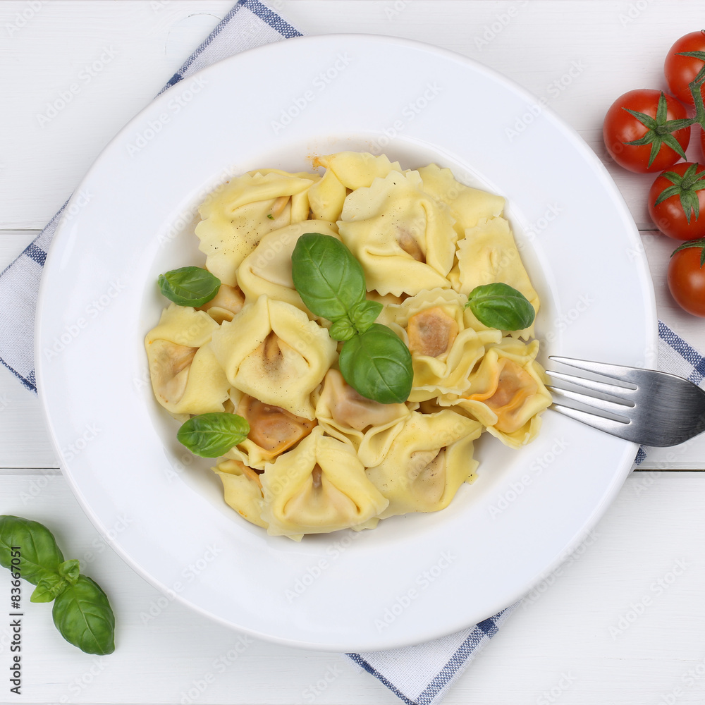 Italienisches Essen Tortellini Nudeln mit Basilikum auf Teller v Italienisches Essen Tortellini Nudeln mit Basilikum auf Teller v