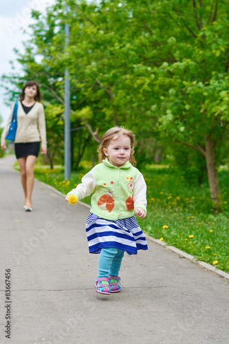 Little girl walks in the park