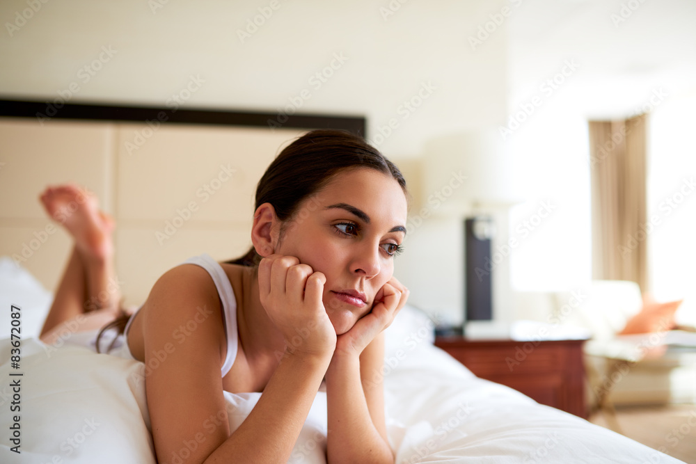 Attractive woman lying in bed looking sad Attractive woman lying in bed looking sad