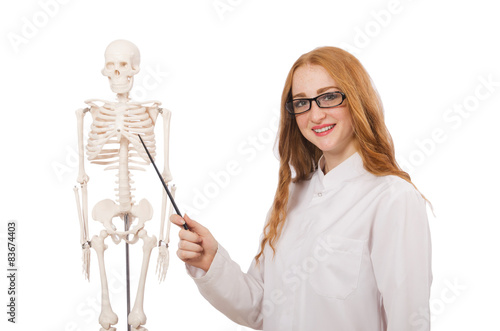 Young female doctor with skeleton isolated on white © Elnur