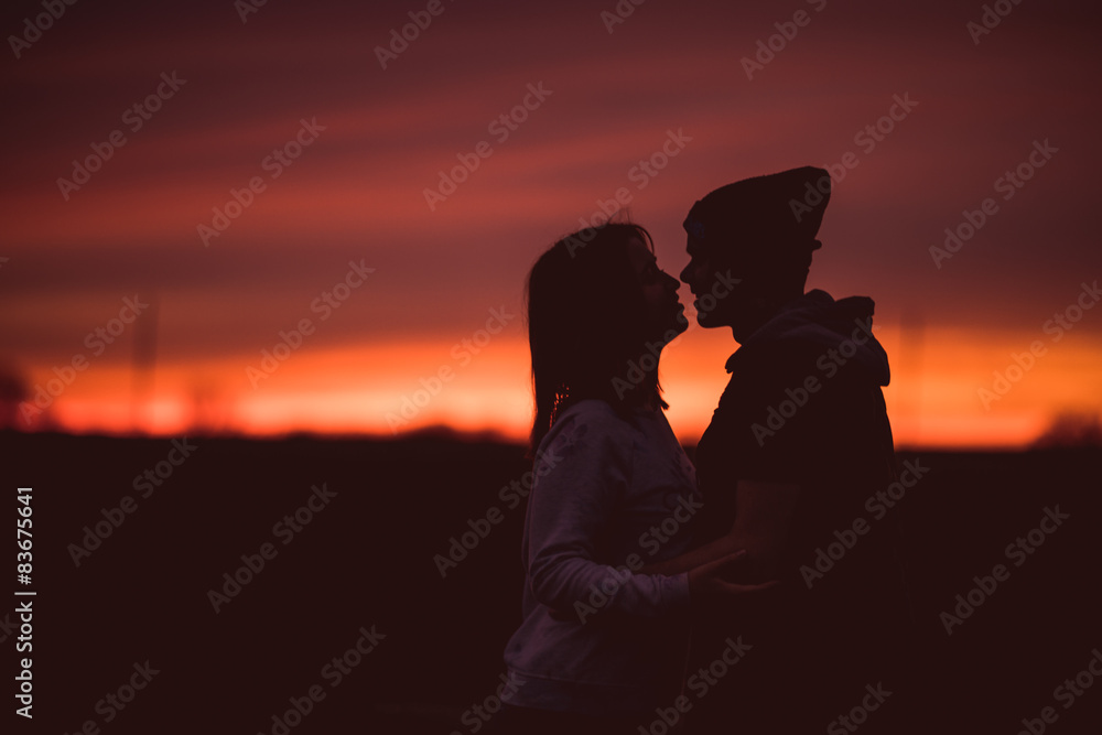 Silhouettes of hugging couple against the sunset 