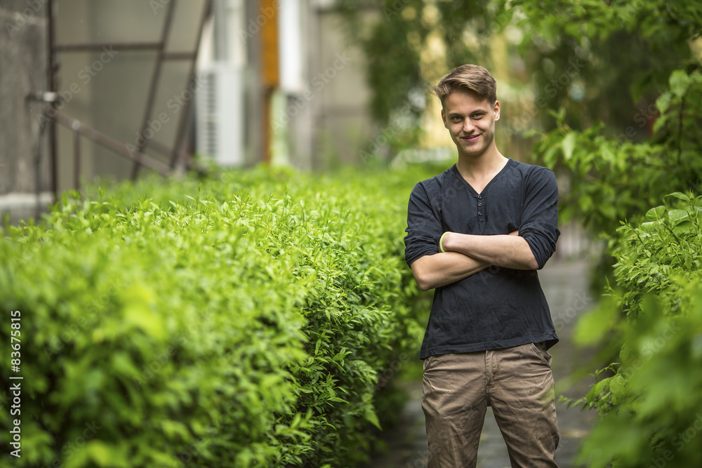 Young charming guy standing outdoors. Young charming guy standing outdoors.