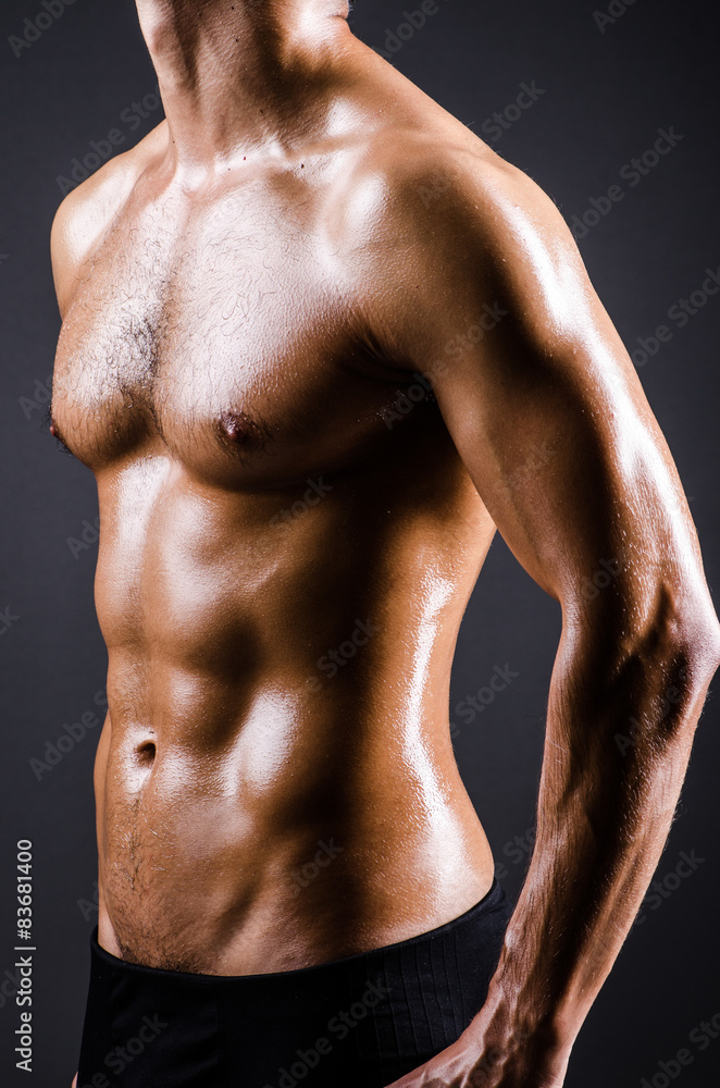 Muscular man posing in dark studio Muscular man posing in dark studio