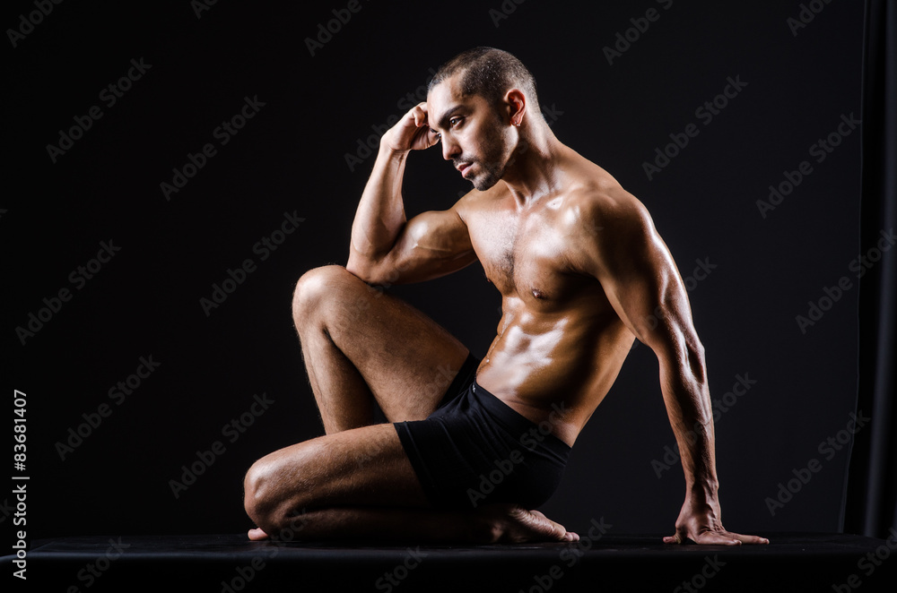 Obraz premium Muscular man posing in dark studio