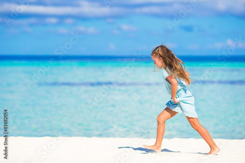 Adorable little girl running on tropical white beach © travnikovstudio
