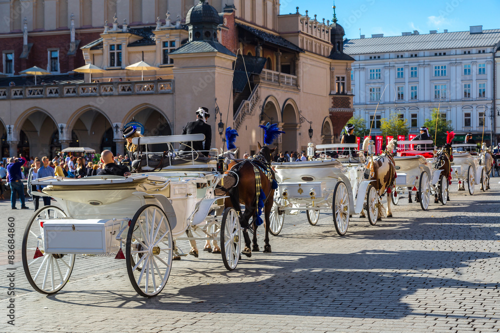 Naklejka premium Horse carriages at main square in Krakow