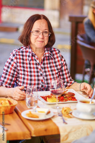 Happy middle aged woman in a restaurant