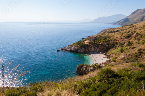 Cove with white beach and pristine blue sea in sicily