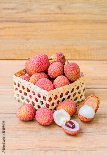 Fresh lychee in bamboo basket on a wooden background