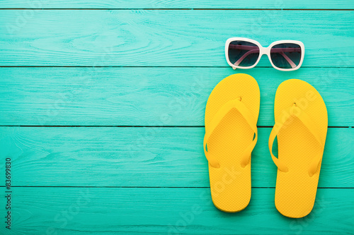 Flip flops and sunglasses on blue wooden background