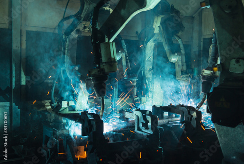 A team of robots welding in automobile parts industry.