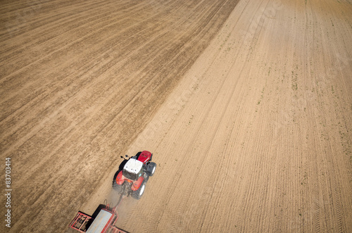 Aerial view of the tractor harrowing the field © Stockr