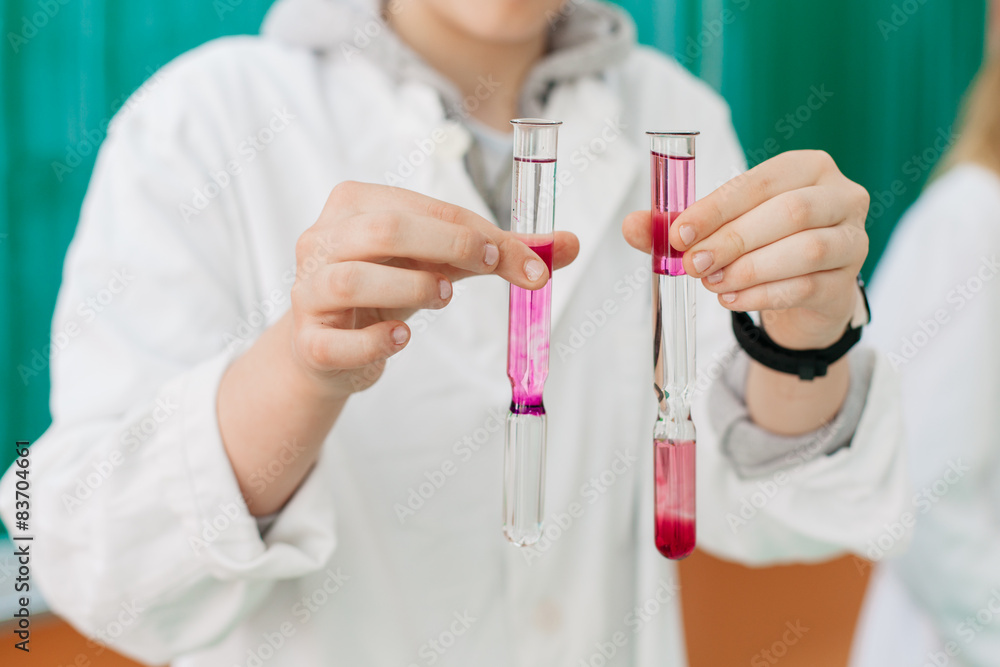 student holding tubes during experiment at chemistry class student holding tubes during experiment at chemistry class