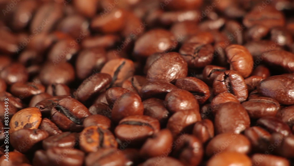 Roasted coffee beans rotates on the table. close-up Roasted coffee beans rotates on the table. close-up