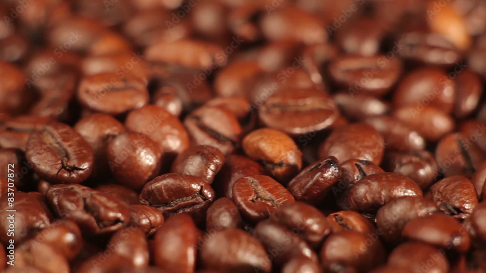 Roasted coffee beans rotates on the table. close-up Roasted coffee beans rotates on the table. close-up