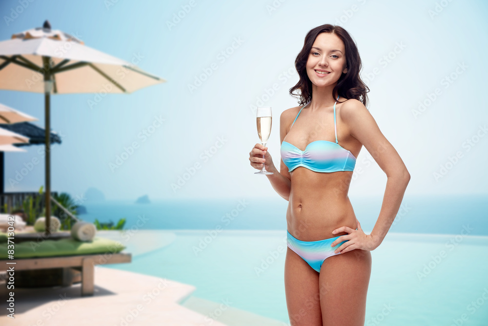 happy young woman in swimsuit drinking champagne