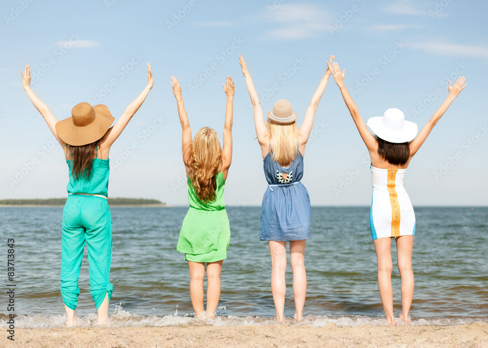 girls with hands up on the beach girls with hands up on the beach